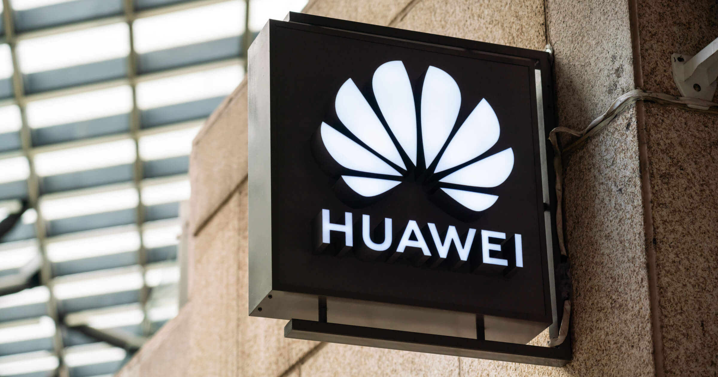 Логотип Huawei на фоне смартфона