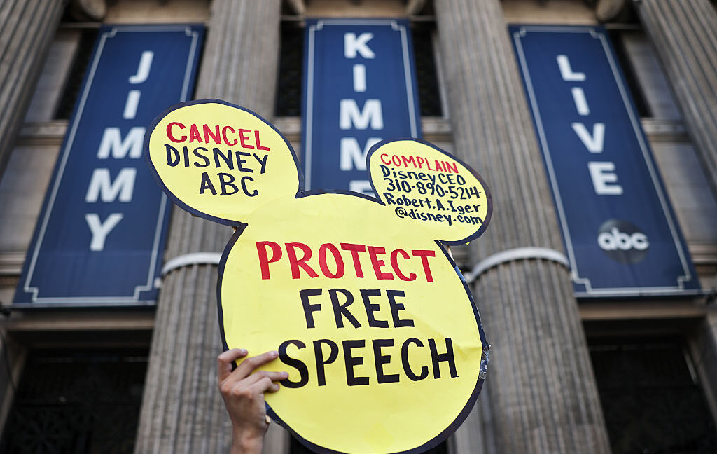 Логотип Disney на экране стримингового сервиса и пульт в руках зрителя